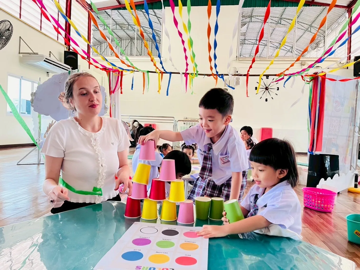 Creative English cup-stacking game with the teacher