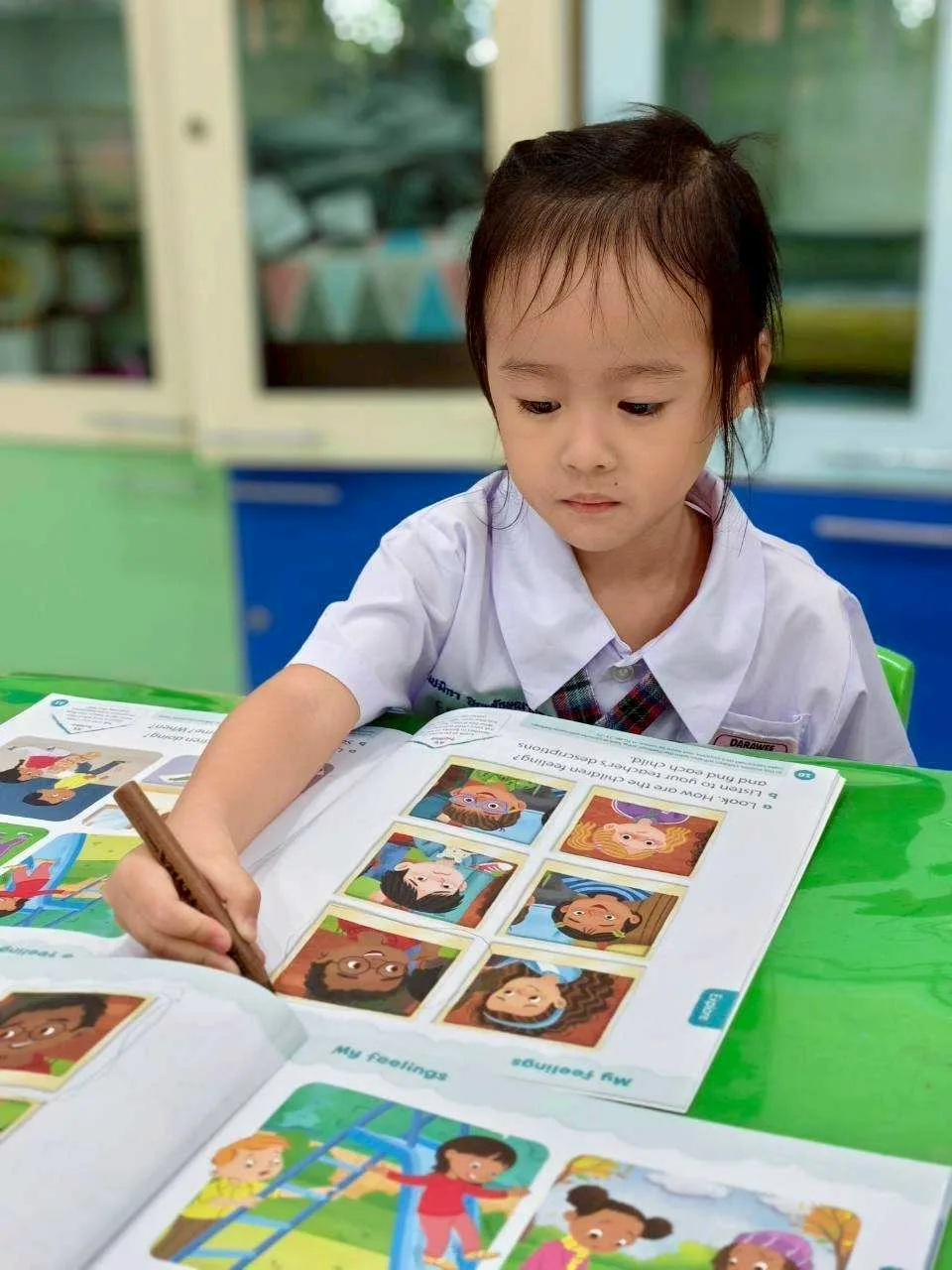 Child pointing while reading a picture book