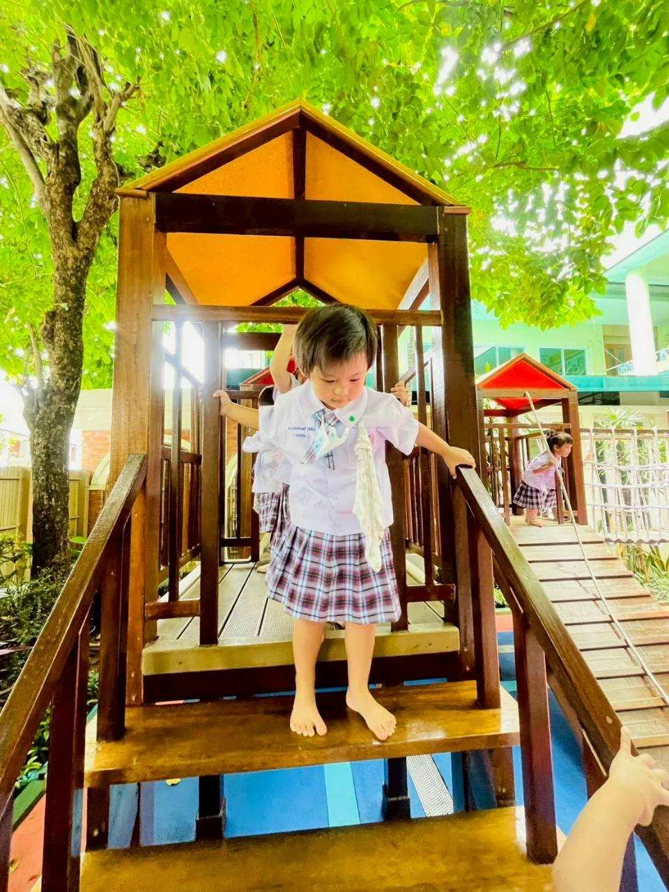 Child on the wooden playhouse slide