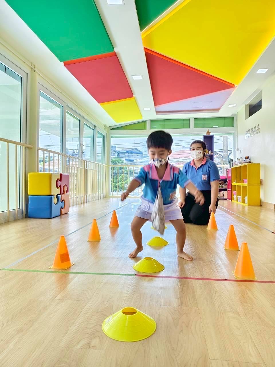 Child moving through obstacle course with teacher