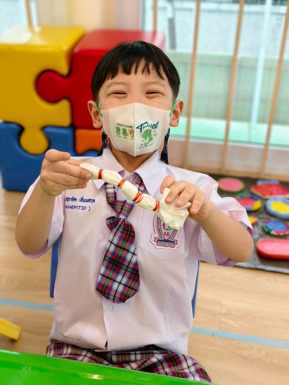 Child smiling with handmade craft