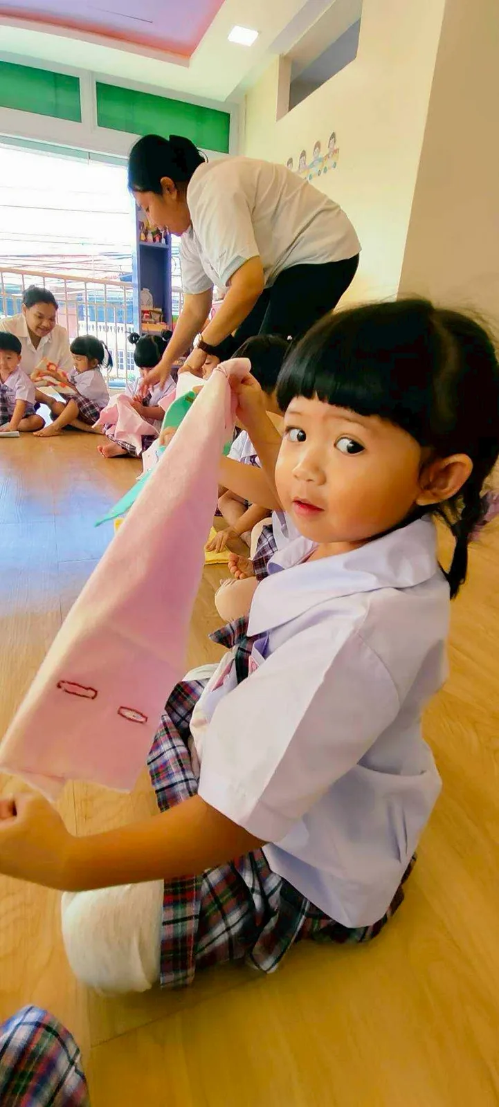 Child in a movement activity with a coloured silk cloth