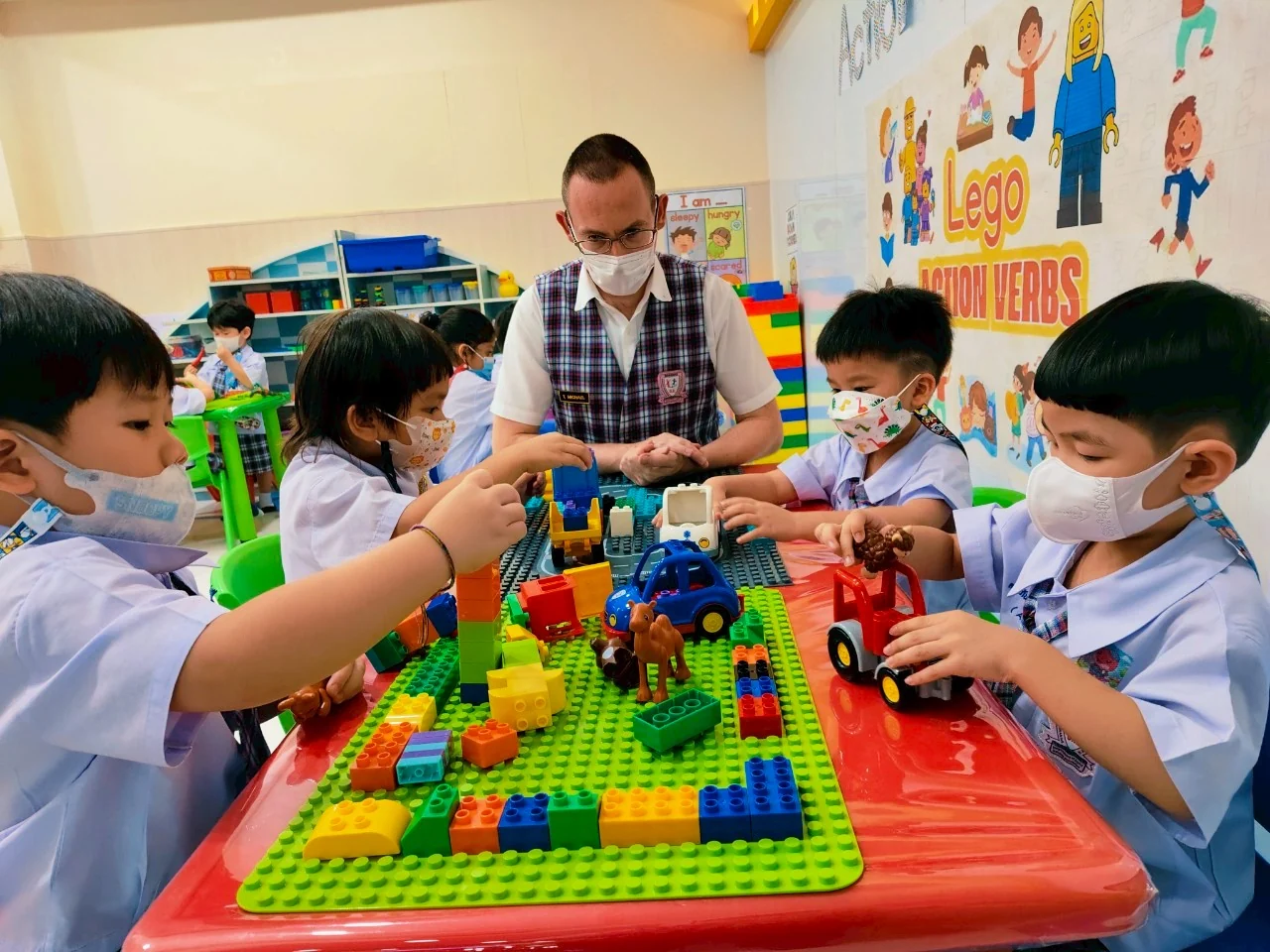 Native-speaker teacher guiding children in an English activity