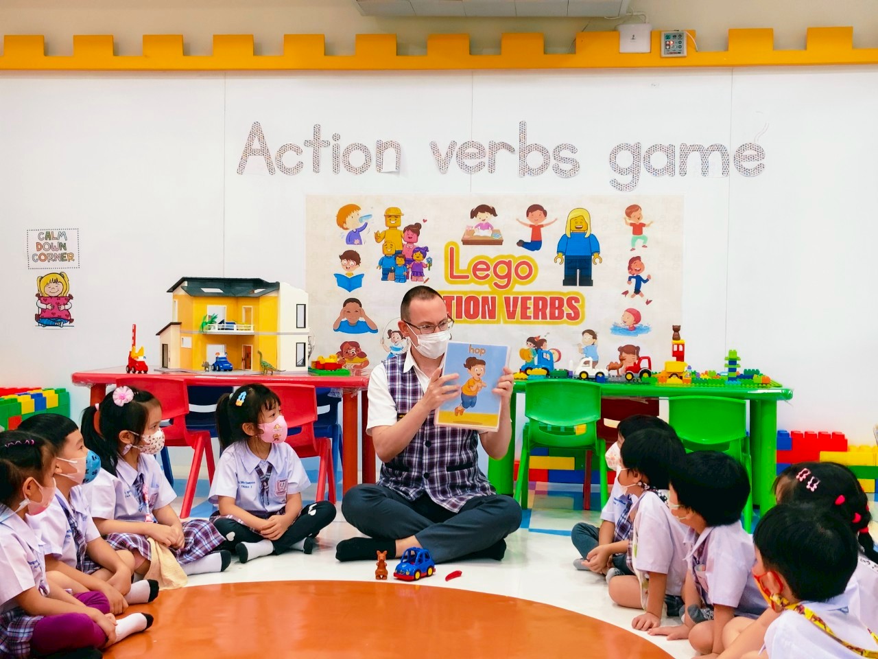 Students building with LEGO guided by English teacher